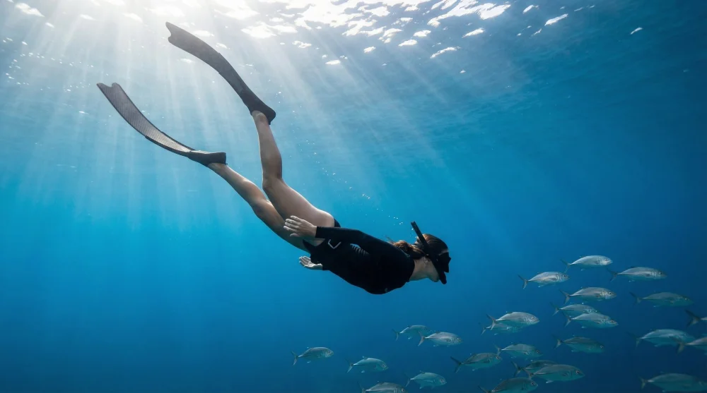 Snorkeler wearing a protective rash guard and diving gear in the deep blue ocean