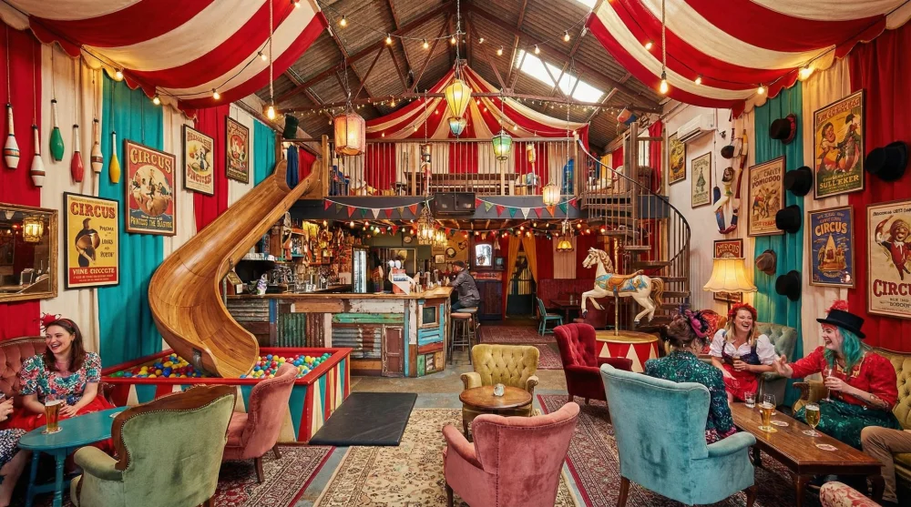 Colorful interior of Unbarlievable bar in Austin with circus decor and a slide.