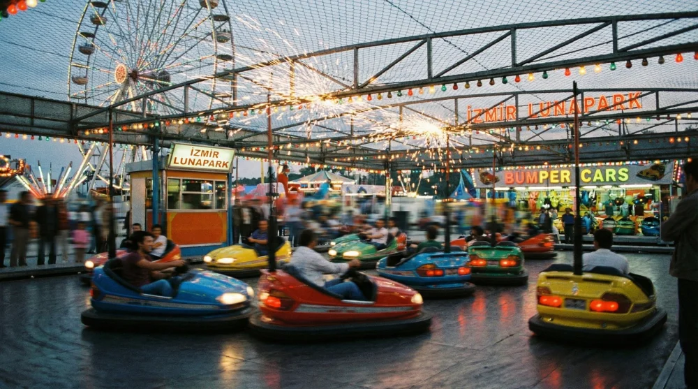 Rengarenk ışıklar altında hareket halindeki klasik &ccedil;arpışan arabalar pisti