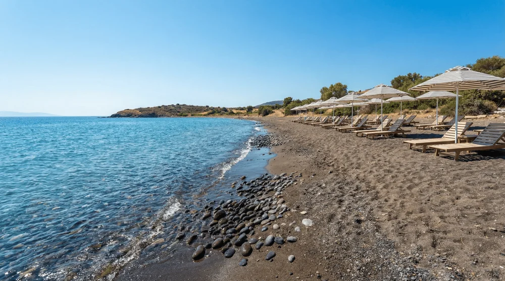 Foça Karakum Plajı'nın kendine has koyu renkli kumsalı ve şezlong düzeni