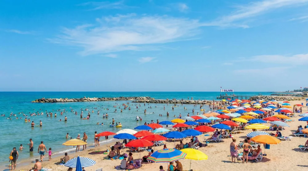 Silivri merkez halk plajında g&uuml;neşlenen insanlar ve dalgakıranlı deniz manzarası