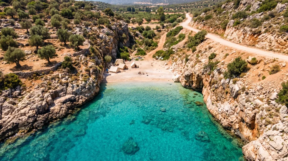 Seyrek Çakıl Plajı'nda kayalıklar arasında kurulmuş kamp çadırları ve berrak deniz