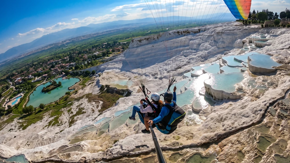 Travertenlerin üzerinde uçan tandem yamaç paraşütü