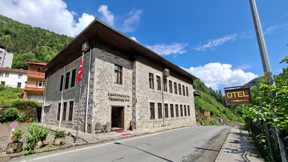 Taşmektep Otel'in taş cephesi ve önündeki köy yolu