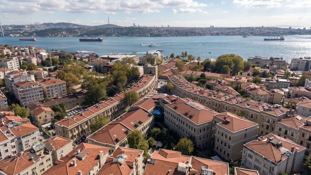 Kiremit çatılı sıra evlerin yukarıdan görünümü ve arkada Boğaz