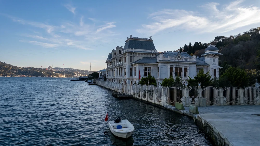 Boğaz kıyısındaki beton yürüyüş bandı ve denize bakan beyaz cepheli yalı
