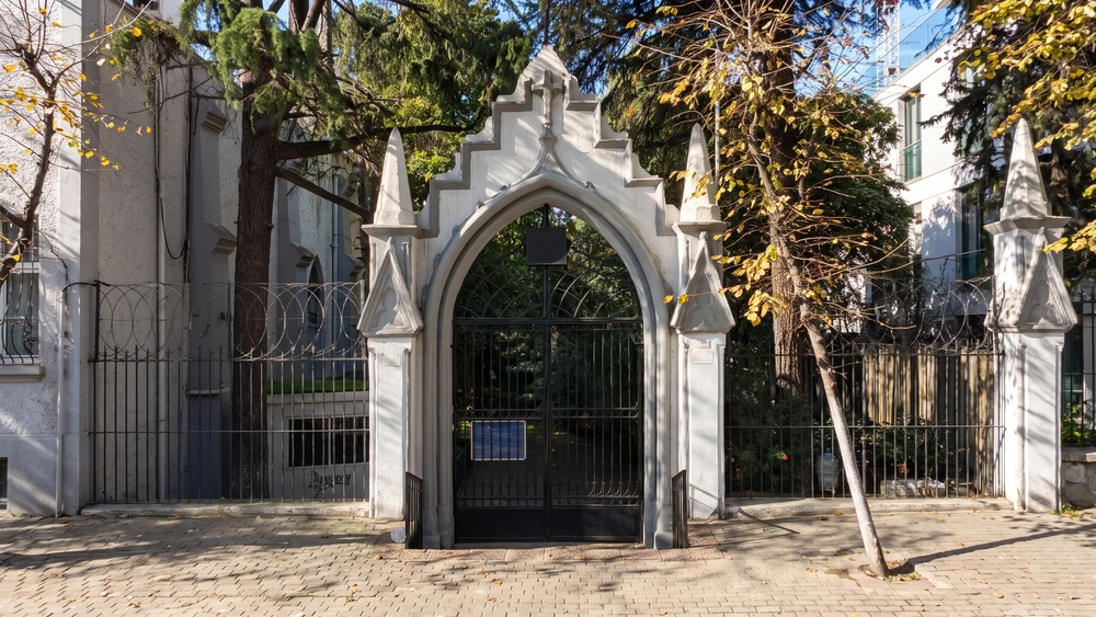Notre Dame de Lourdes kilisesinin sivri kemerli beyaz taş kapısı ve demir kapı girişi