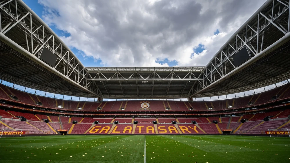 Rams Park stadyumunda GALATASARAY yazılı tribünler ve saha, bulutlu gökyüzü