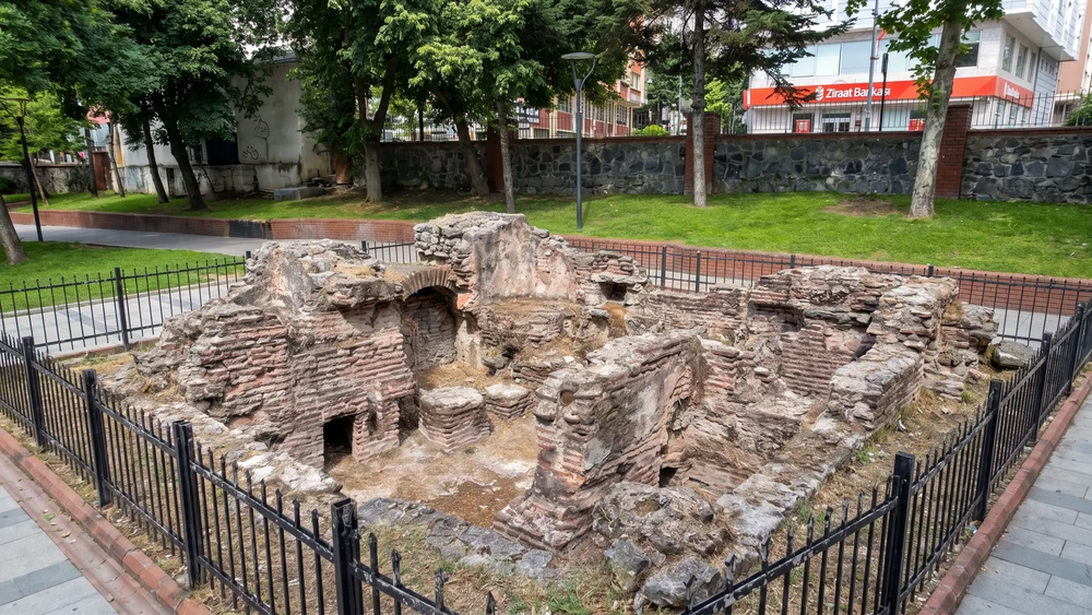 Park içindeki tuğla ve taş kalıntılar, çevresinde demir korkuluk