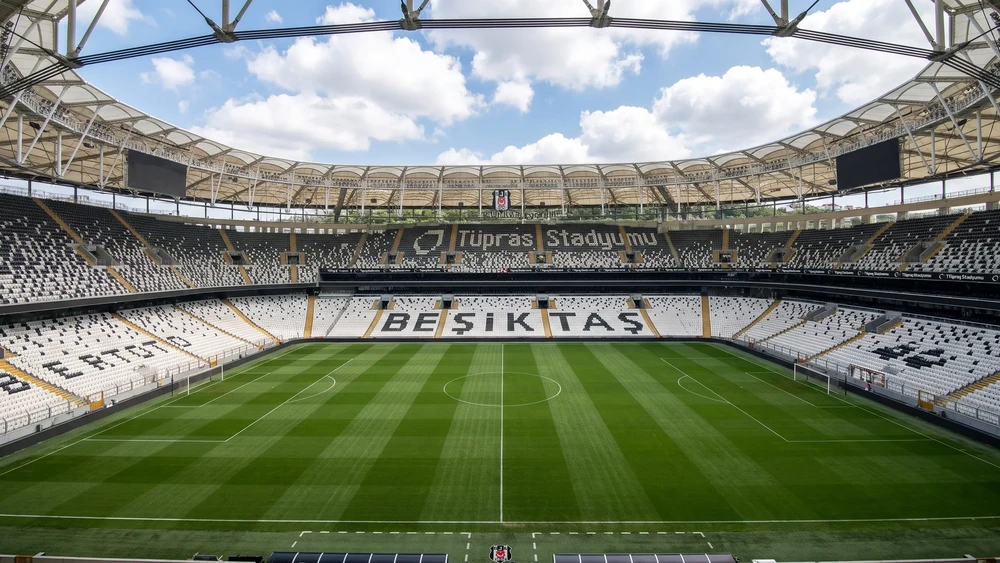 Tribünlerden sahaya bakış, karşı tribünde BEŞİKTAŞ yazısı ve çatı örtüsü.